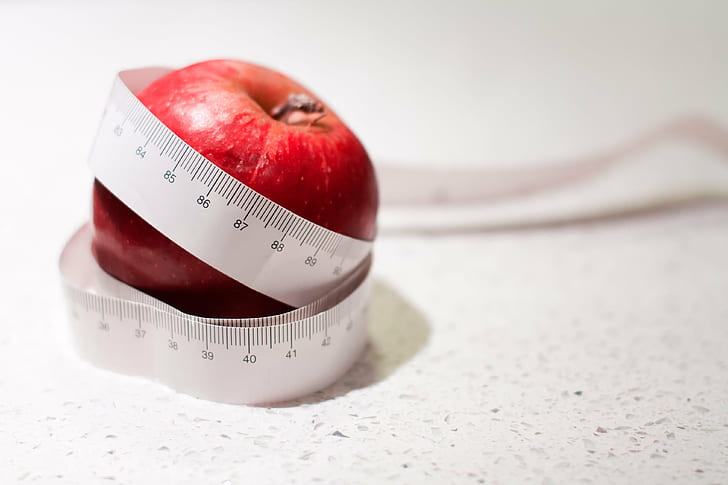 selective focus photography of apple wrapped by measuring tape, apple