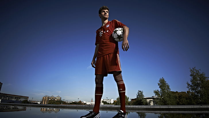 man in red soccer jersey shirt and short holding white ball, Football