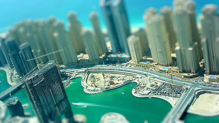 city building scale model, aerial photography of city with high rise buldings surrounded with body of water