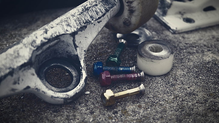 four gray metal bolts, skateboard, screws, close-up, equipment