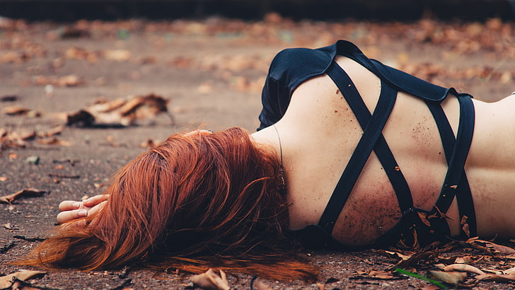 women's black crop top, woman lying on ground surrounded with leaves