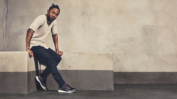man in gray shirt and black pants sitting on concrete stand, Kendrick Lamar