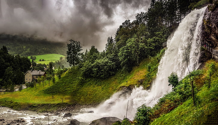 waterfall surrounded by green trees, forest, mountains, clouds