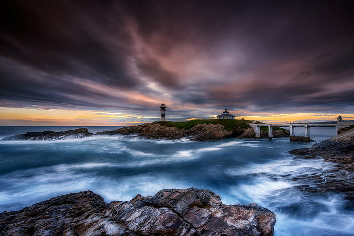 lighthouse on island connected with white bridge on sea under dramatic clouds, HD wallpaper