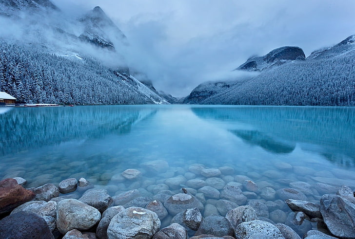 landscape photography of gray stone in body of water during cloudy season