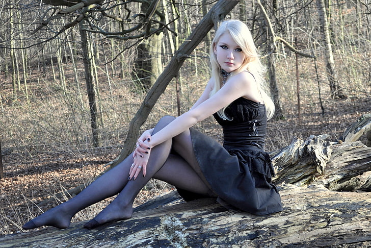 women's black mini dress, blonde, pantyhose, sitting, outdoors