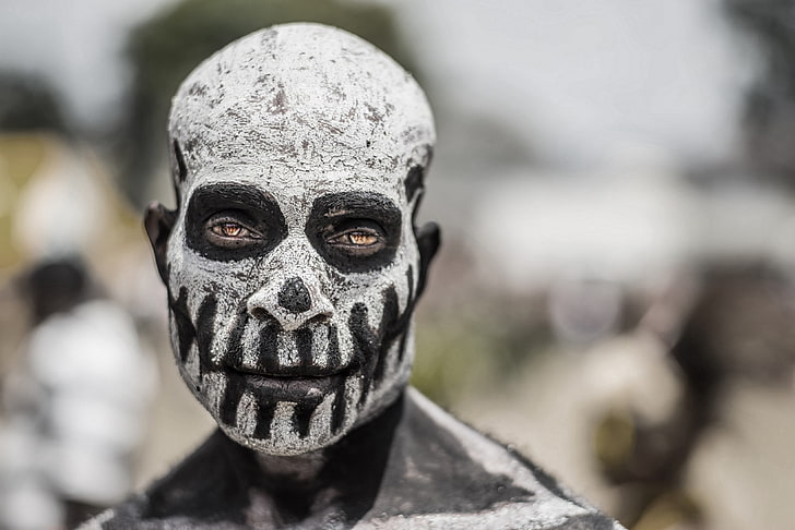 white and black skull face paint, African, body paint, men, close-up
