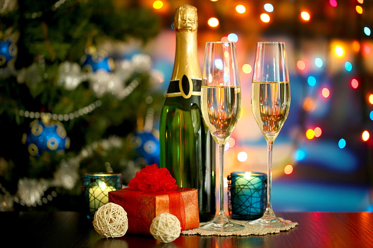 selective focus photography of flute glasses beside champagne bottle