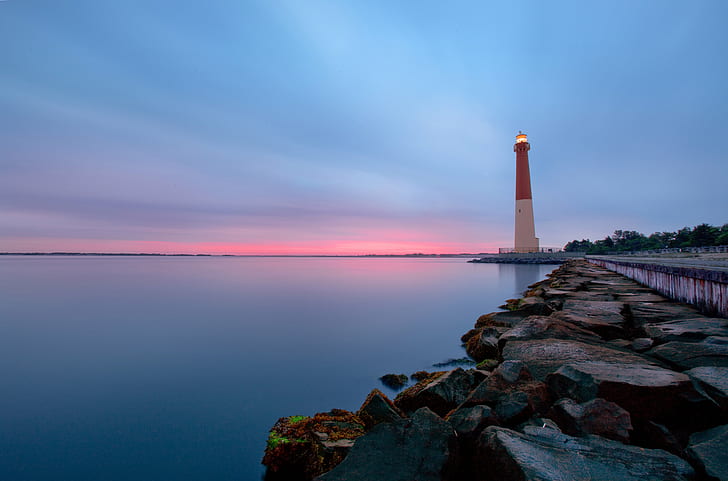 white and red lighthouse beside calm body of water, Calm Before the Storm
