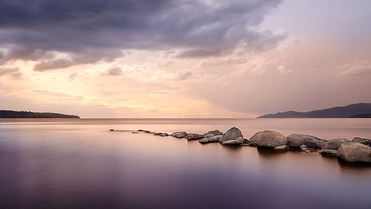 body of water with seawall, calm waters, landscape, sky, stones