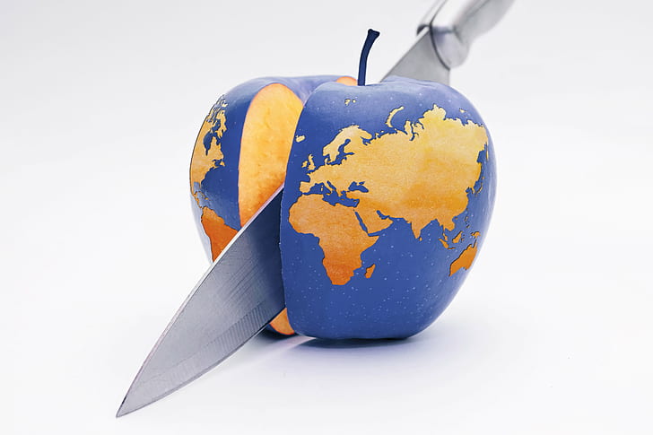 stainless steel kitchen knife slicing blue apple with map print