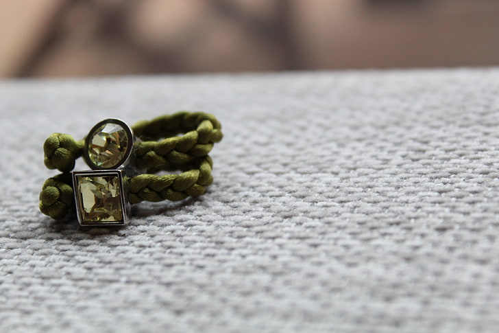 green bracelet, two green paracord bracelets on white textile