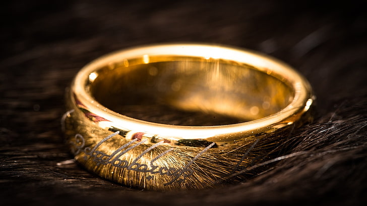 gold-colored ring, gold-colored ring on brown wooden surface