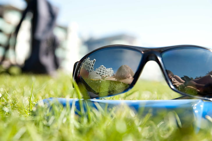 shallow focus photography of black sunglasses on green grass during daytime