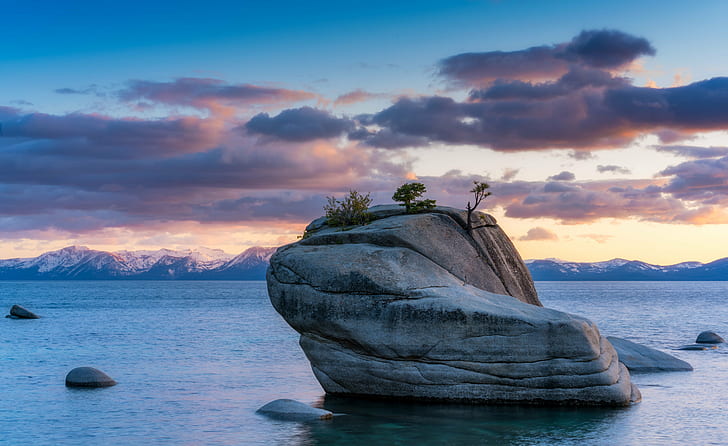 gray rock monolith with trees surrounded by water, lake tahoe, lake tahoe