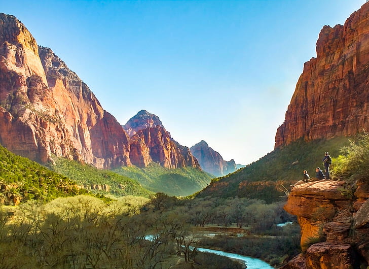 three person standing on brown rock formation near forest with river during daytime, zion national park, zion national park
