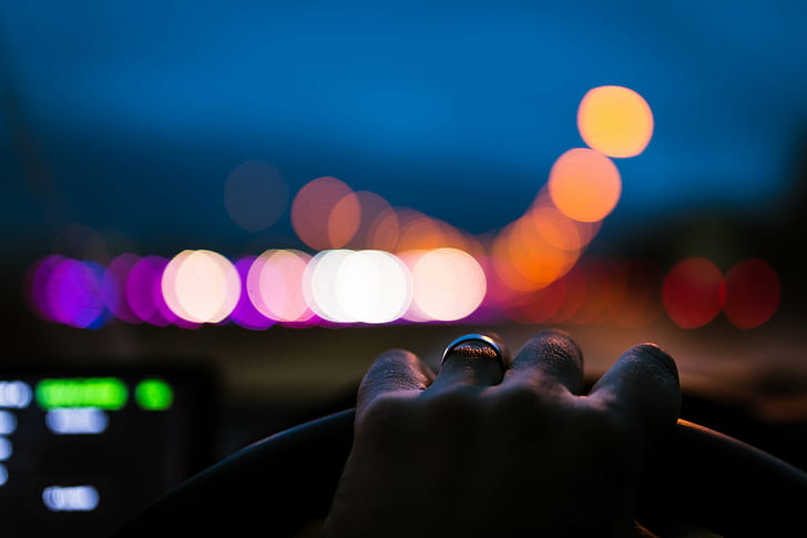 person with silver ring holding car steering wheel, night, nightlife