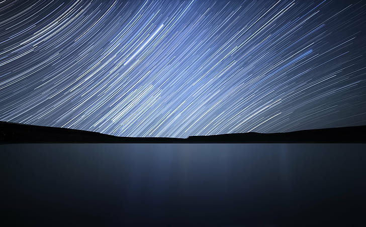 time lapse photography of calm body of water under starry sky