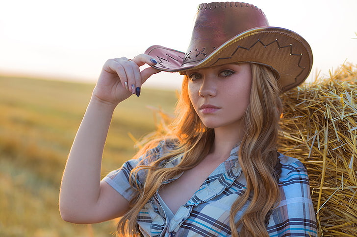 women's brown leather cowboy hat, blonde, plaid shirt, hay, cowboy hats