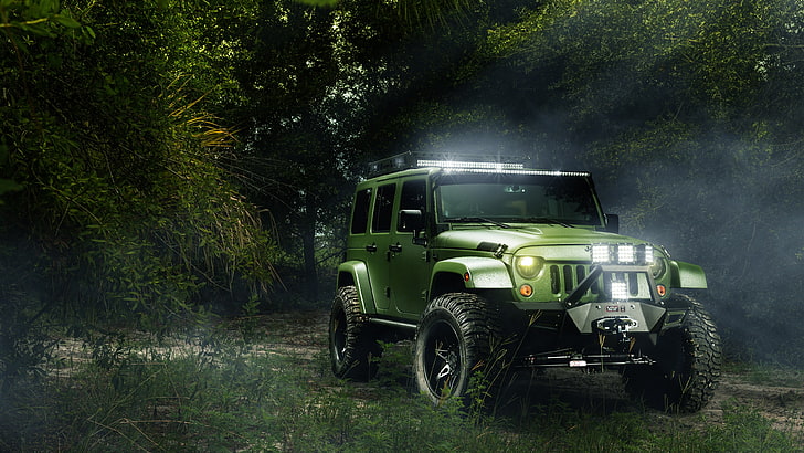 green Jeep Wrangler Unlimited on green grass between trees, landscape