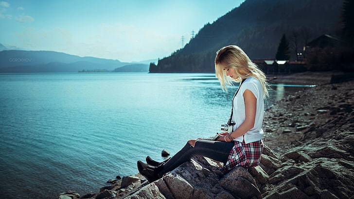 woman wearing white shirt and black denim jeans sitting on rocks in front of sea during daytime, HD wallpaper