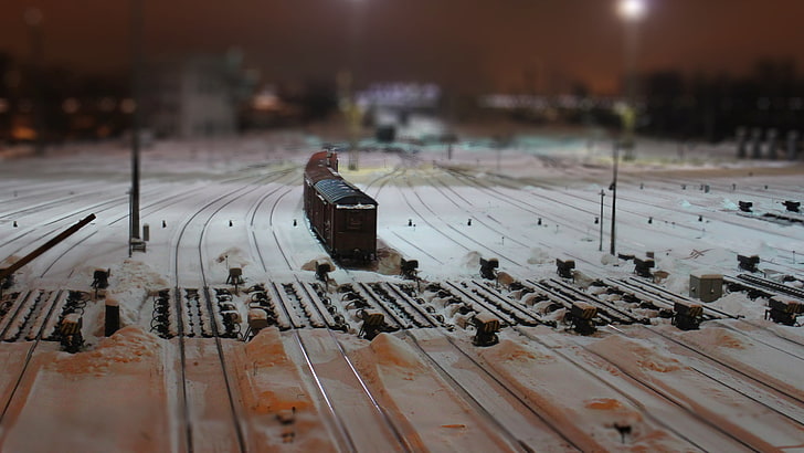 black train toy, shallow focus photo of brown miniature train on rail tracks