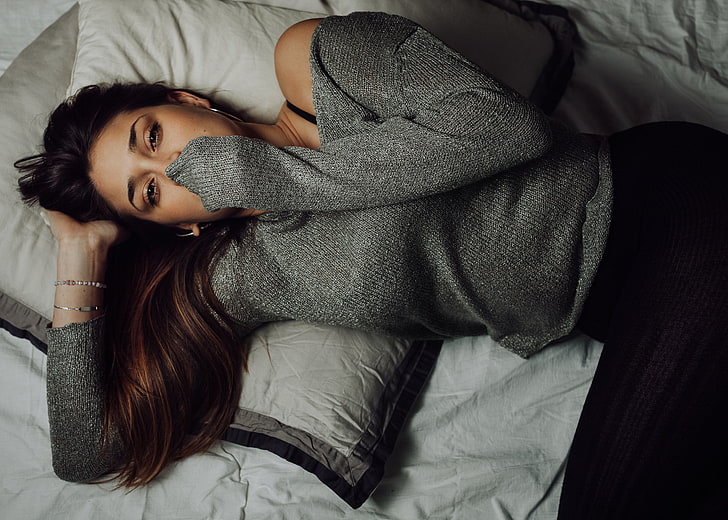 woman in gray long-sleeved shirt lying on bed, women, top view