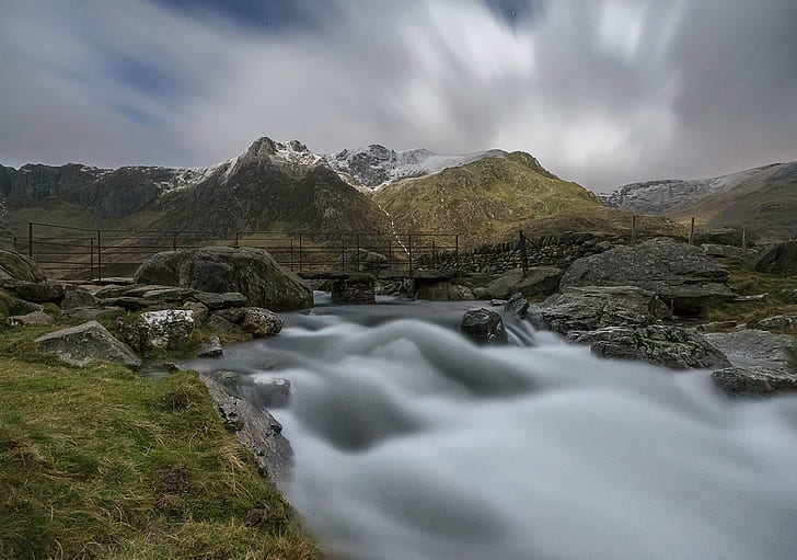 time lapse photograph of river stream between rock formation under gray sky, snowdonia, snowdonia