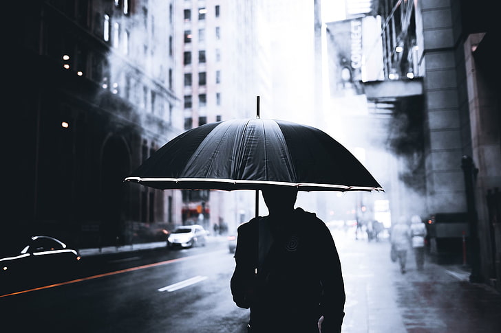 black umbrella, photo of person using umbrella passing high rise buildings