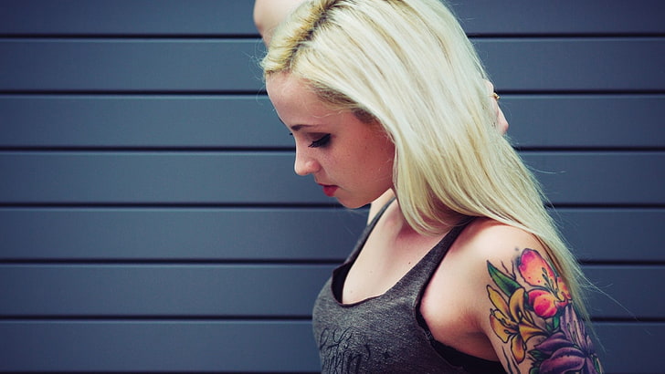 blonde haired woman in grey tank top touching her hair, model