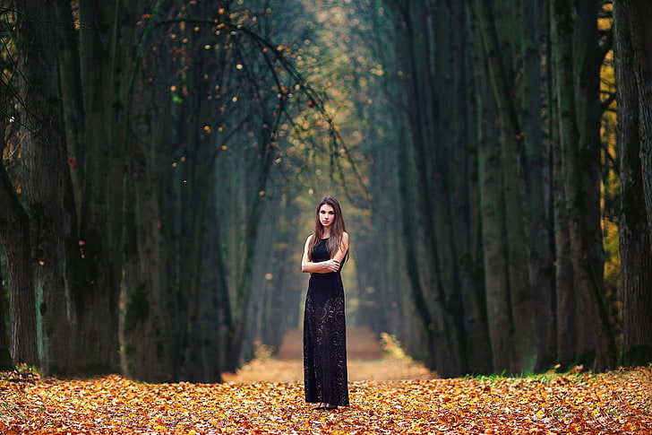 women's black sleeveless maxi dress, woman with black floral sleeveless standing on brown leaves covered pathway