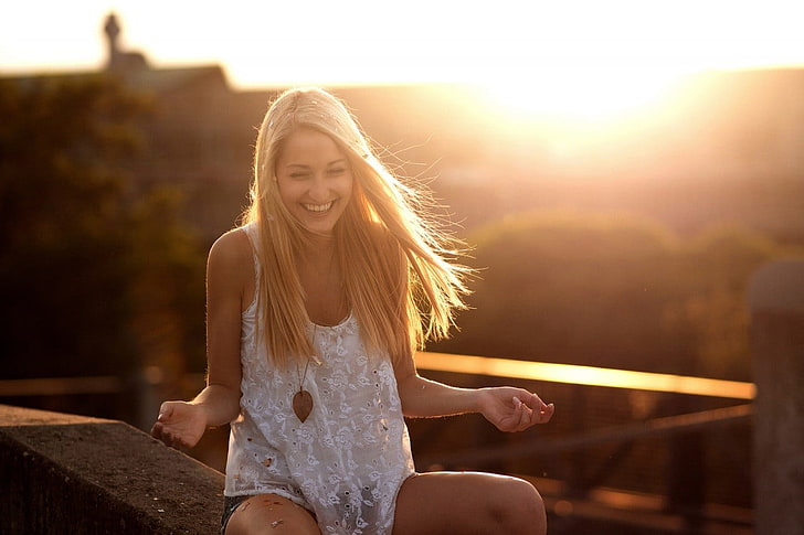 women's white lace spaghetti strap top, blonde haired woman in white floral lace tank top sitting on concrete surface