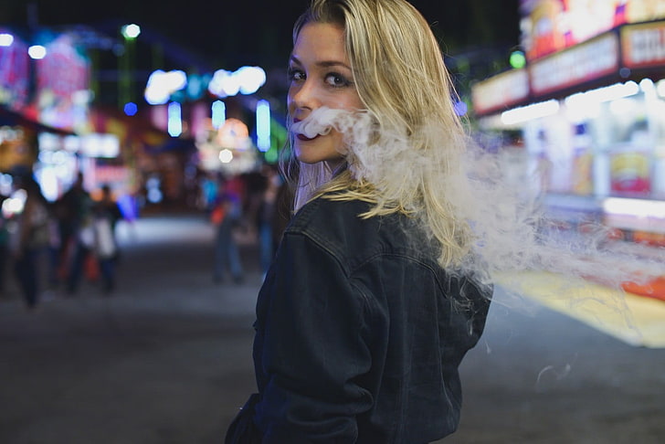 women's black jacket, close up photograph of woman with smoke in mouth in street