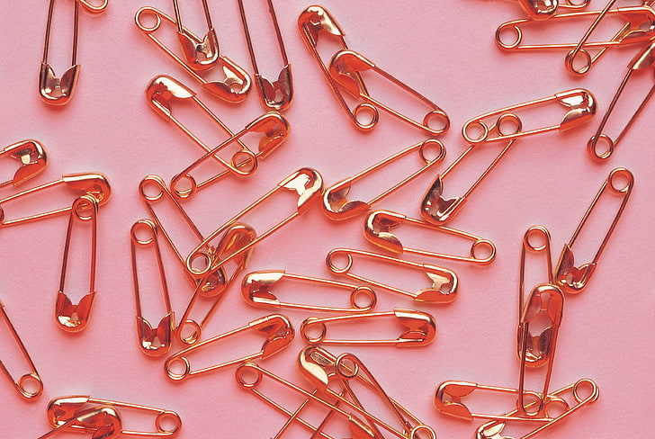 gold safety pin lot, pins, metal, pink background, paper Clip