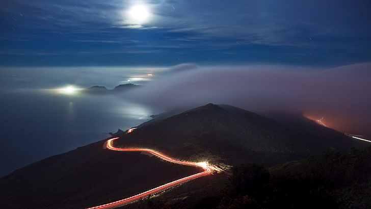 time lapse photography of vehicle lights surrounding mountain