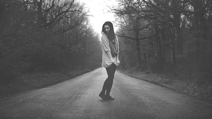 Girl standing on road, black and white