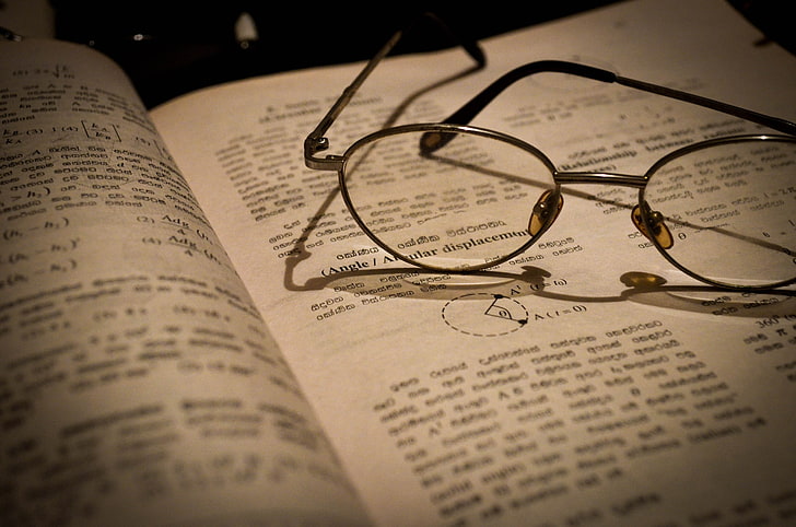 eyeglasses with silver frames, books, macro, text, beige, paper