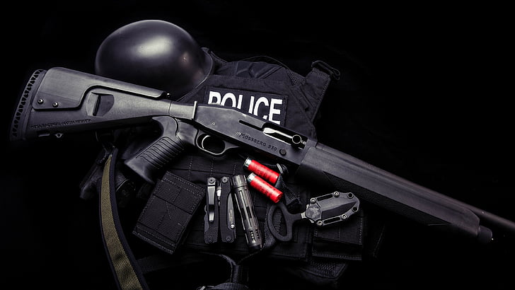 black shotgun, black police tactical vest and shotgun shells with black background
