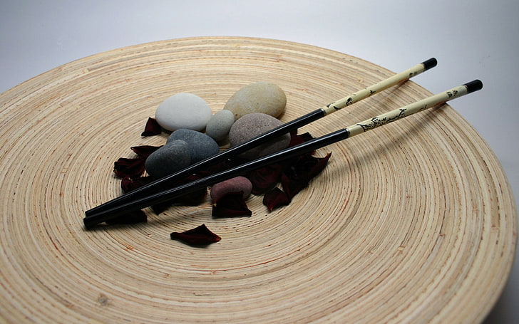 black and gray fishing rod, chopsticks, stones, petals, wood - material
