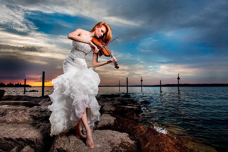 woman playing violin, stones, shore, violinist