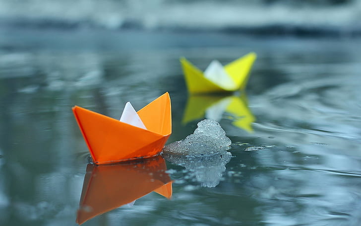 Small paper boats in water