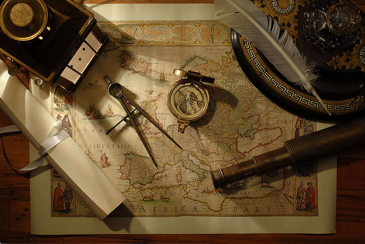 Africa map and several handheld tools, pen, compass, spyglass