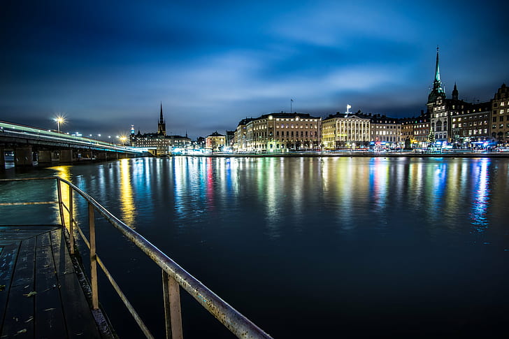 photography of brown concrete buildings near body of water during night time, stockholm, stockholm