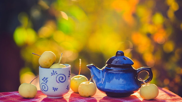 blue ceramic teapot and white and blue ceramic mug, fruit, bokeh