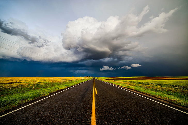 gray asphalt road path under white and blue sky, storm chasing