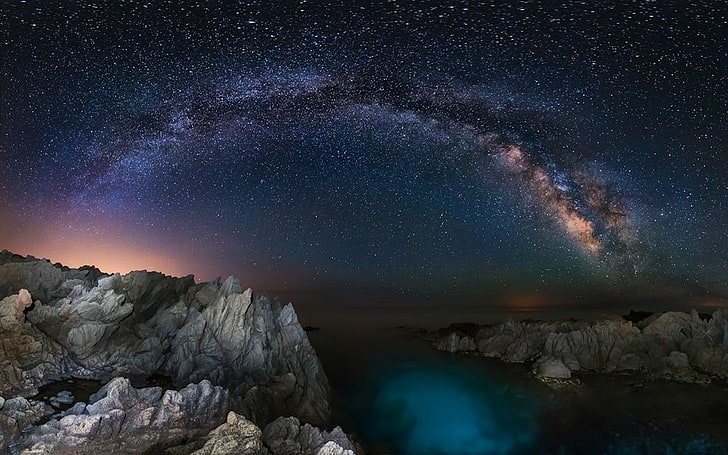 rock cliff with body of water under milky way, starry night, long exposure