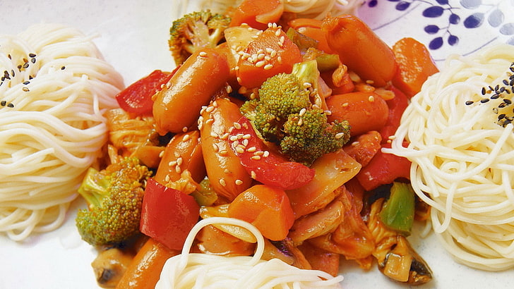 plate of stir fry food, spaghetti, vegetables, sausages, sesame
