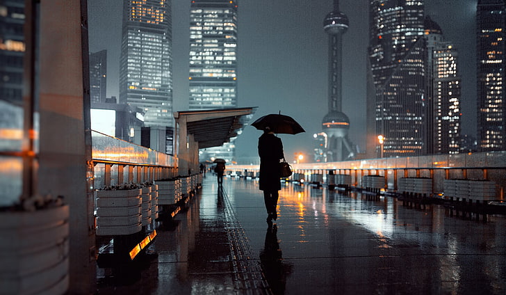 black umbrella, person holding umbrella walking on street during nightime