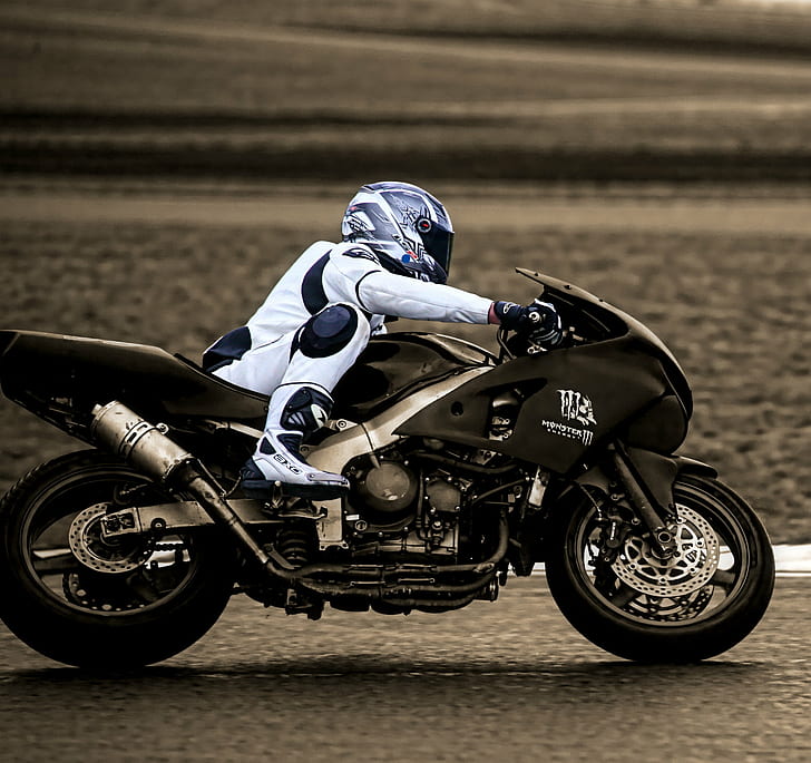 timelapse photography of man riding black sports bike wearing white motorcycle gear on black asphalt pavement