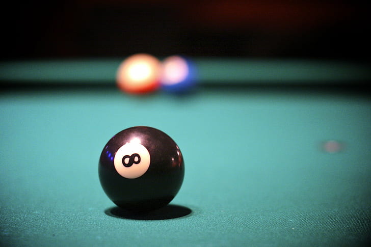 selective focus photography of 8 billiard ball on table, behind the eight ball
